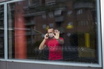 Un homme sérieux au téléphone regardant par la fenêtre — Photo de stock