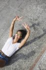 Young woman in sunglasses lying down in bright sunlight — Stock Photo