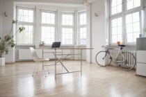 Laptop on table in sparse office — Stock Photo