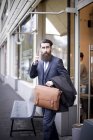 Hipster mit Aktentasche und Smartphone verlässt Café — Stockfoto