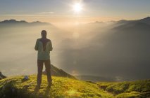 Hiker looking at distance at sunrise — Stock Photo