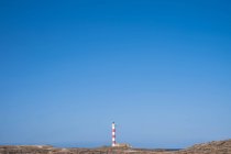 View to lighthouse on deserted coast — Stock Photo