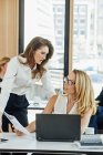 Two businesswomen working together at office desk — Stock Photo
