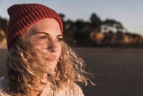 Ragazza adolescente che indossa berretto guardando lontano in spiaggia — Foto stock