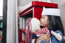 Bambina abbracciare e baciare la sua bambola — Foto stock