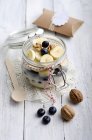Conserver le pot de flocons d'avoine arrosés, tranches de banane, bleuets et noix — Photo de stock