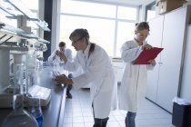 Trois chimistes travaillant dans un laboratoire chimique — Photo de stock
