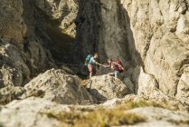 Austria, Tirolo, Tannheimer Tal, giovani coppie che fanno escursioni sugli scogli — Foto stock