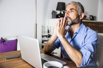 Ritratto di uomo d'affari in preda al panico che lavora con il computer portatile in ufficio — Foto stock