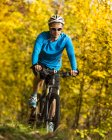 Їде mountaimbike в осінній ліс — стокове фото