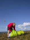 Man packing his paraglider in the field — Stock Photo