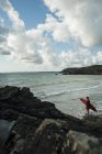 Frankreich, bretagne, camaret-sur-mer, jugendlicher junge mit surfbrett am meer — Stockfoto