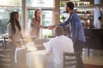 Pessoas cumprimentando uns aos outros em uma reunião de negócios em um restaurante — Fotografia de Stock