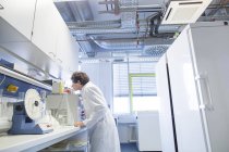 Technikerin bringt Probe an einen Rotator im Labor für Biochemie — Stockfoto