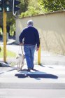 Uomo ipovedente che attraversa una strada con il suo cane guida — Foto stock