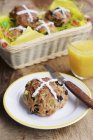 Hot cross buns on plate with knife — Stock Photo