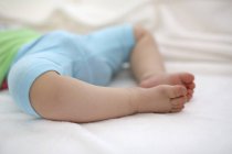 Jambes de bébé fille endormie — Photo de stock