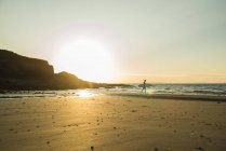 Серфера на пляжі на захід сонця, Франції, Бретань, Камаре сюр Мер — стокове фото