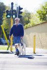 Sehbehinderter Mann überquert mit Blindenhund eine Straße — Stockfoto