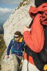 Austria, Tirol, Tannheimer Tal, pareja joven caminando sobre roca - foto de stock