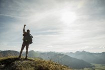 Österreich, Tirol, Tannheimer Tal, Junger Mann jubelt auf Berggipfel — Stockfoto