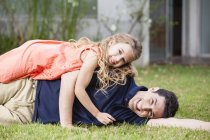 Verspielter Vater und Tochter liegen im Gras — Stockfoto