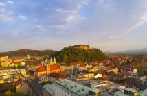 Eslovénia, Liubliana, centro da cidade de Liubliana, Castelo de Liubliana e Igreja Franciscana da Anunciação à luz da tarde — Fotografia de Stock
