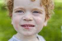 Retrato de un niño sonriente cubierto de helado - foto de stock