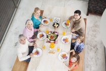 Розширена сім'я з салатом і соком за обіднім столом — стокове фото