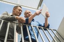 Два бизнесмена используют цифровые планшеты на открытом воздухе — стоковое фото