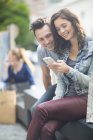 Portrait of young couple using smartphone — Stock Photo