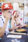 Kinder verkleiden sich als Piraten auf einer Party am Tisch mit Pizza — Stockfoto