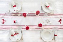 Red-white laid table with candles and place settings — Stock Photo