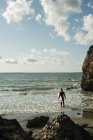 Франция, Британия, Камаре-сюр-Мер, подросток с доской для серфинга на берегу океана — стоковое фото