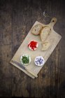 Goat cheese with nasturtium, chives and lavender on chopping board — Stock Photo