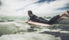 Francia, Bretagne, Camaret sur Mer, Teenage boy surfing en la costa atlántica. - foto de stock