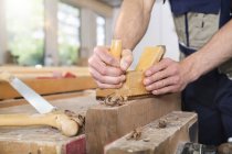 Carpenter planing wood in workshop — Stock Photo