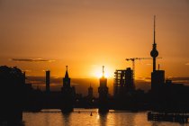 Alemania, Berlín, Friedrichshain-Kreuzberg, puente de Oberbaum y río Spree, Berlin TV Tower al atardecer - foto de stock
