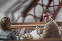 Due giovani studenti caucasici seduti in una biblioteca — Foto stock