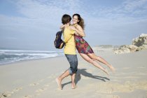 South Africa, man lifting up girlfriend on the beach — Stock Photo