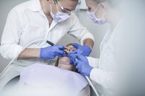 Dentista che esegue un controllo di routine per il suo paziente — Foto stock