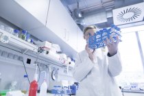 Jeune femme scientifique travaillant dans un laboratoire biologique inspectant des échantillons — Photo de stock