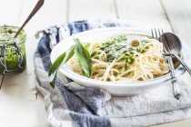 Spaghetti con ramson di pesto e foglie di aglio selvatico, strofinaccio da cucina sul tavolo di legno — Foto stock