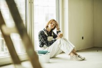 Exhausted young woman having a break from renovating — Stock Photo