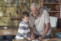 Nonno e nipote lavorano con il legno in un garage — Foto stock