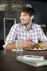 Молодой человек в ресторане обедает — стоковое фото