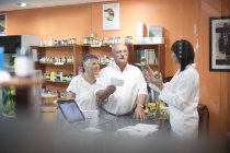 Femme magasin de santé pharmacien conseiller couple aîné — Photo de stock