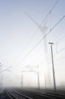 Deutschland, Hamburg, Windkraftanlage neben Bahngleisen im Frühnebel — Stockfoto