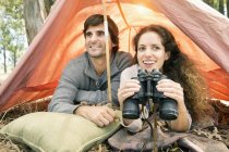 Sudáfrica, feliz pareja con prismáticos en tienda de campaña - foto de stock