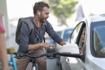 Homme à vélo parlant à une femme en voiture — Photo de stock